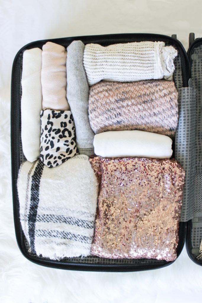 Blush pink packed suitcase. packing heavy vs. packing light for every vacation type.