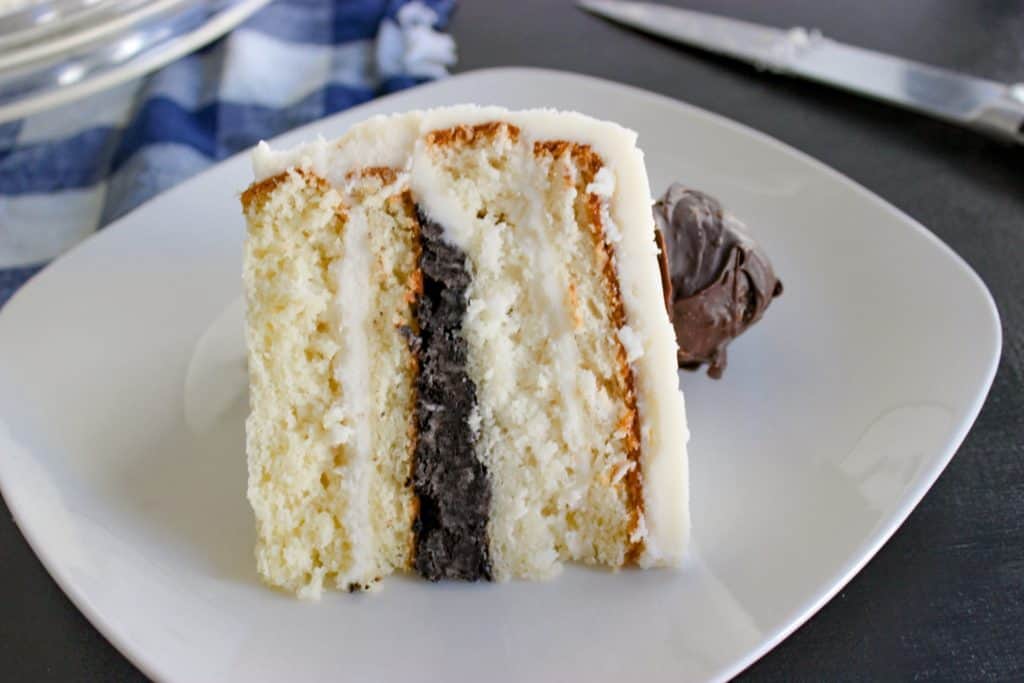 This easy cake recipe is delicious and very rich. The homemade butter cream frosting is my favorite and there is a surprise oreo ball filling layer inside the cake. The whole white cake is topped with homemade oreo balls. I made this as a birthday cake for my husband but you could make it as a mothers day cake, easter cake or really anything thanks to its rustic and neutral exterior. It is a simple baking recipe to try now.