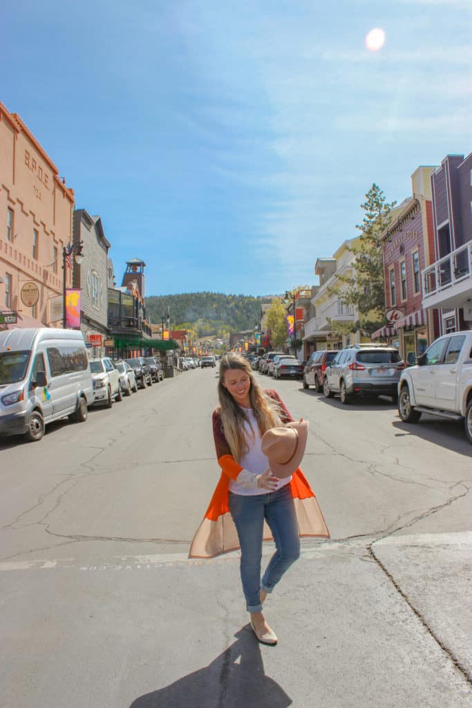 Girl standing on Park City main street during fall.