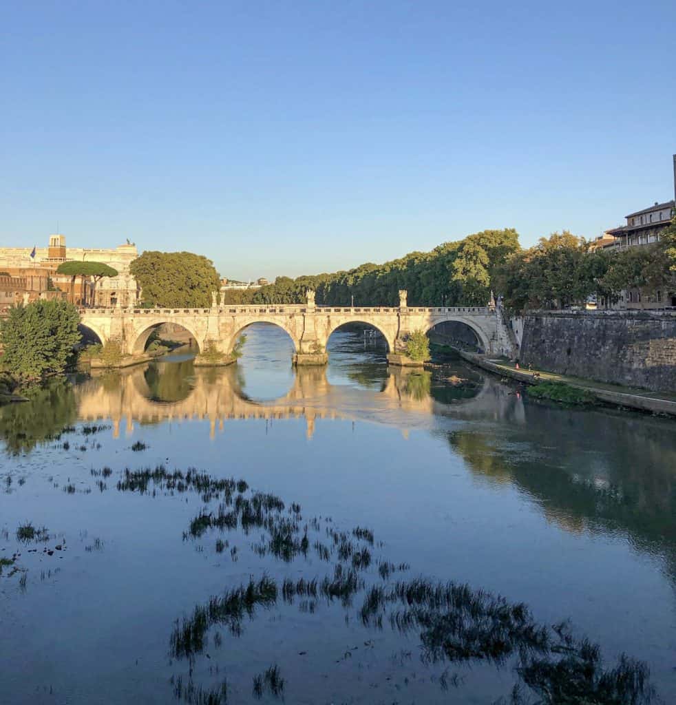 The calm and beautiful scene of the river tiber flowing under a bridge. On the left is San't Angelo Castelo. Rome, Italy is full of history on every corner, Just imagine the sights this river has seen. A peaceful activity to do in Rome would be to walk along side the river Tiber. Perhaps bring a picnic and observe daily life.