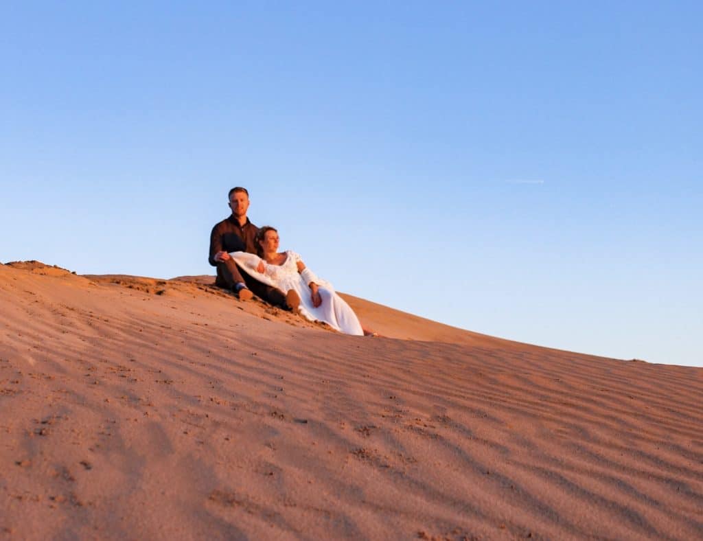 Traveling as a couple is important to grow and strengthen a relationship. This couple is traveling together and exploring the sand dunes.