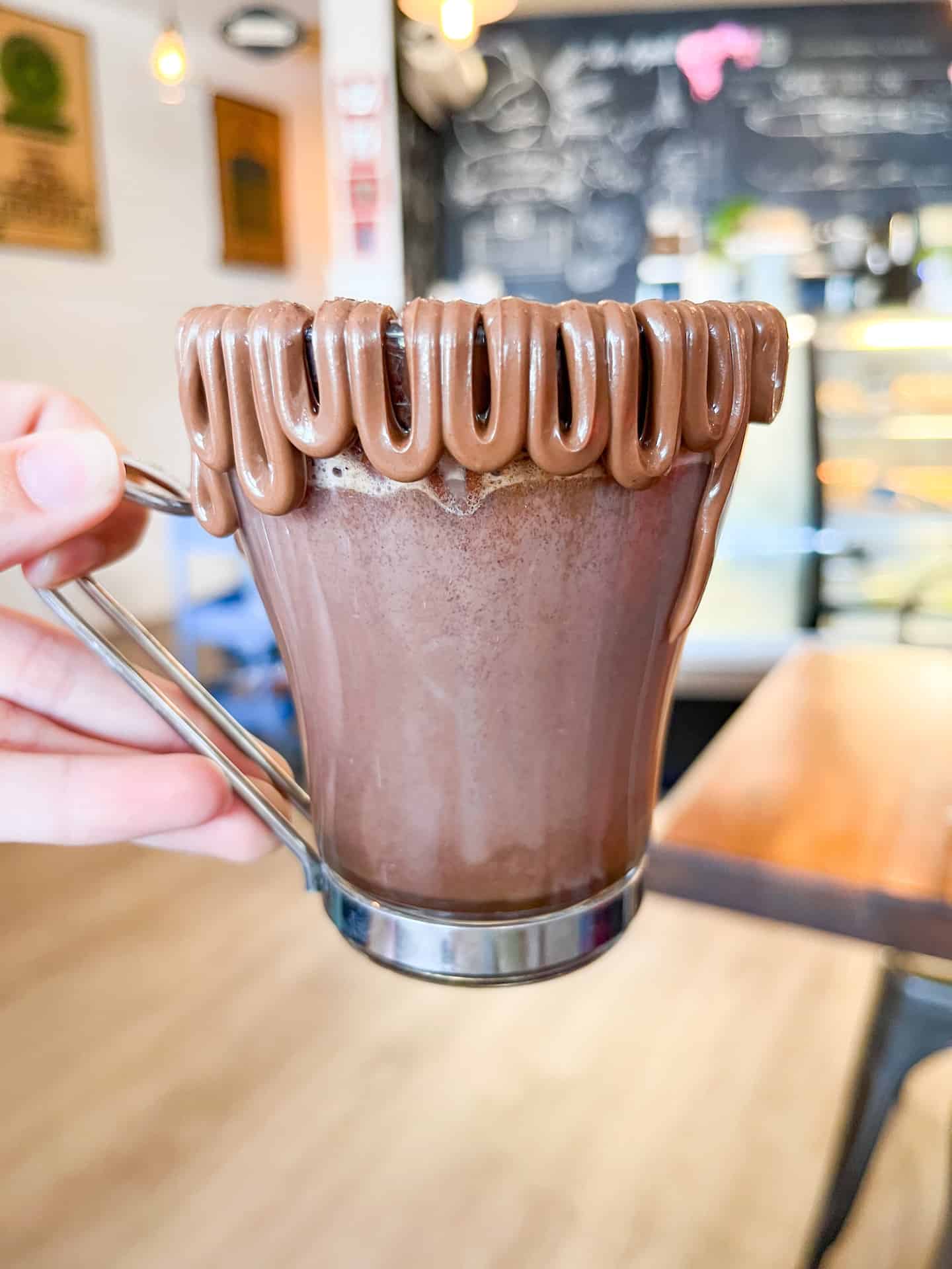 a glass of hot chocolate where the rim is decoratively covered in nutella.