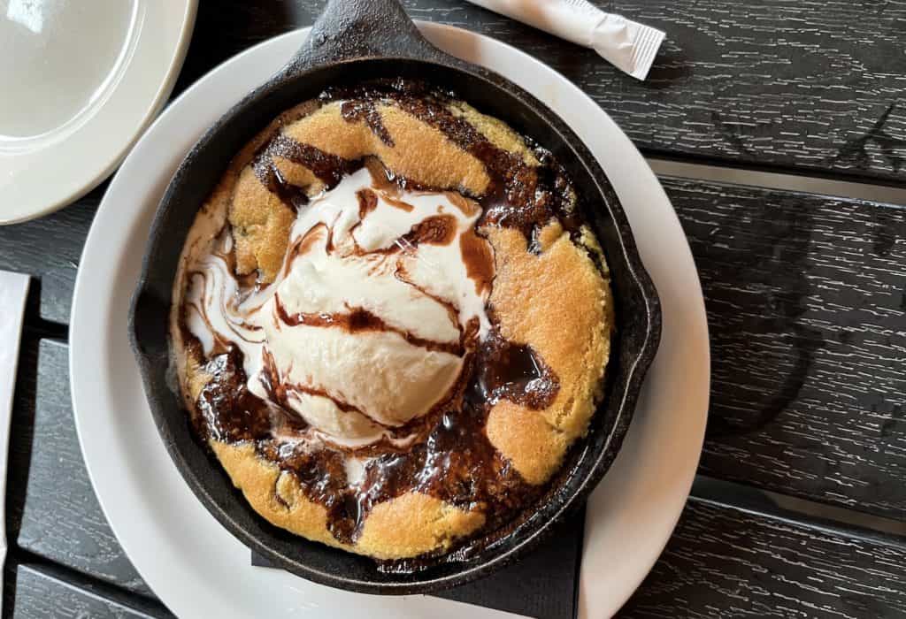 Chocolate chip cookie skillet with ice cream melting on top.
