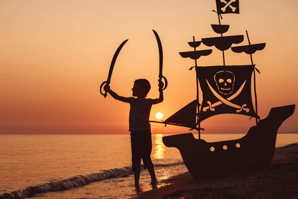 a child playing pirate on the beach after visiting the Tampa Bay History Center a great museum to visit with kids in tampa.