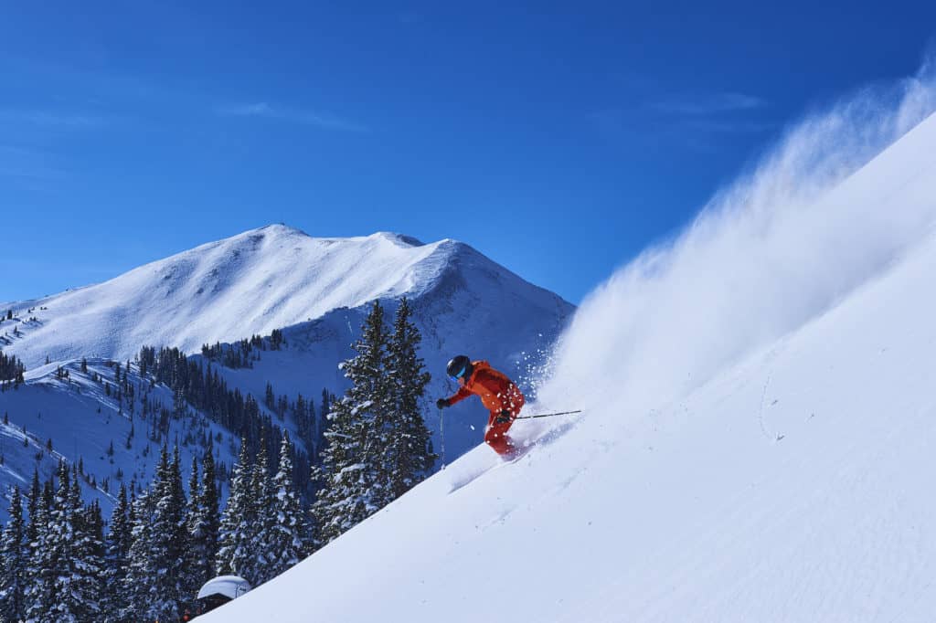 Man skiing down the mountain side on winter vacation in Colorado, one of the best winter destinations in the US.