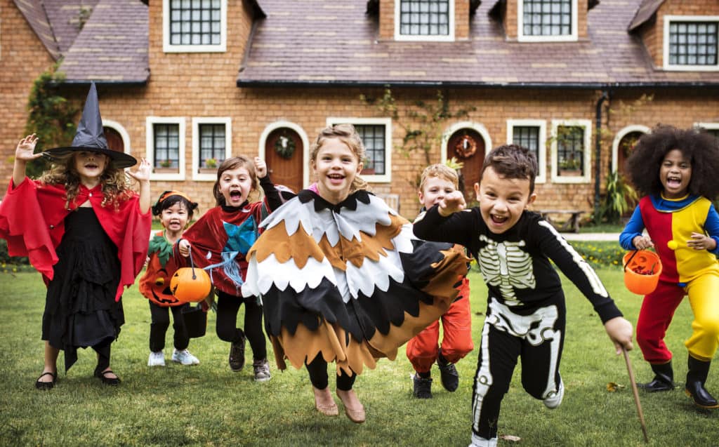 Kids trick or treating dressed in different costumes. Trick-or-treating events are the best fun fall events for kids in Tampa and there are so many to choose from.