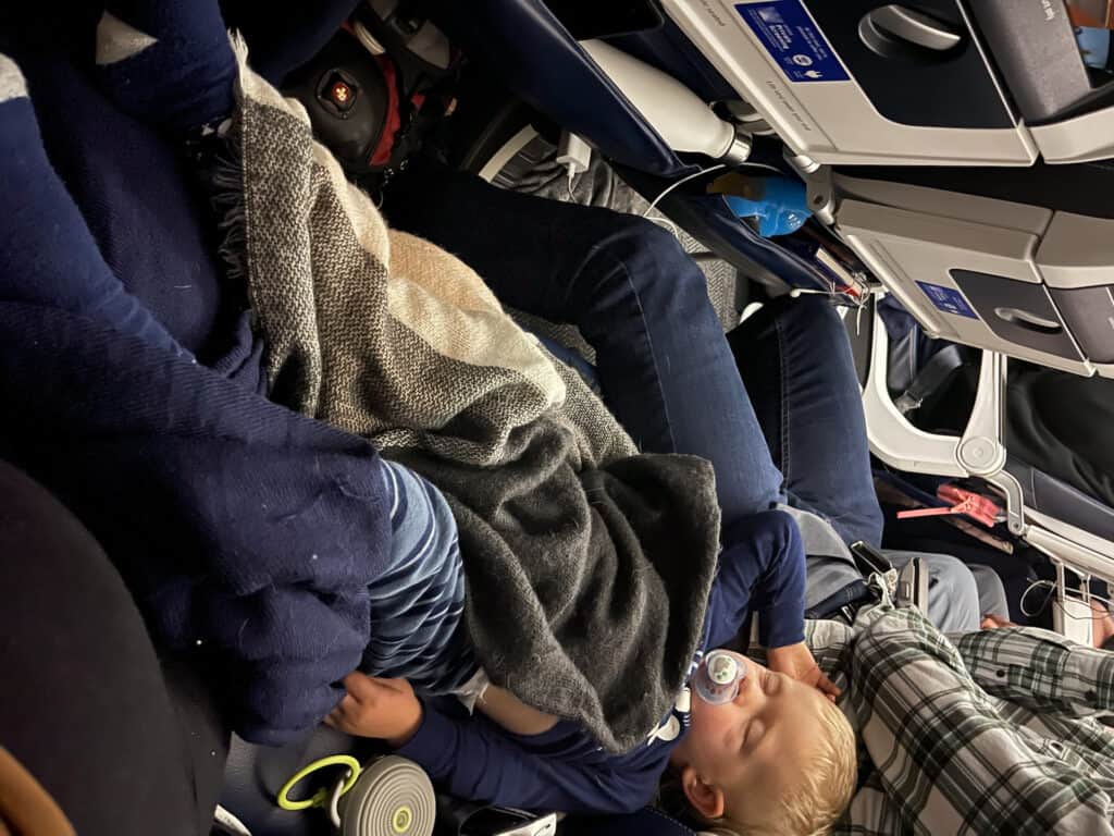 You can get your toddler to sleep on a plane with the help of flight essentials like a sound machine, blanket and comfort items like a binkie.