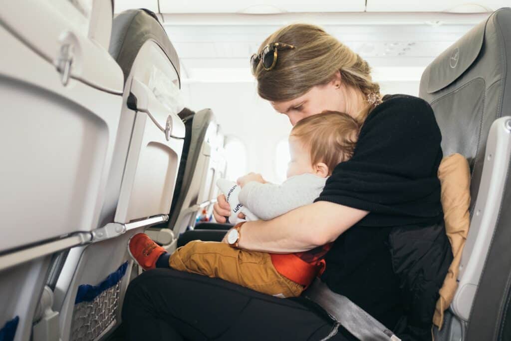 Mom and baby playing on an airplane.