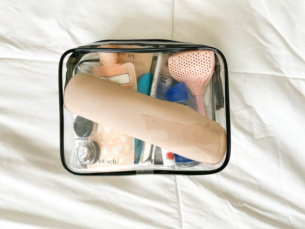 The makeup brush holder packed into a small carry-on toiletry bag.