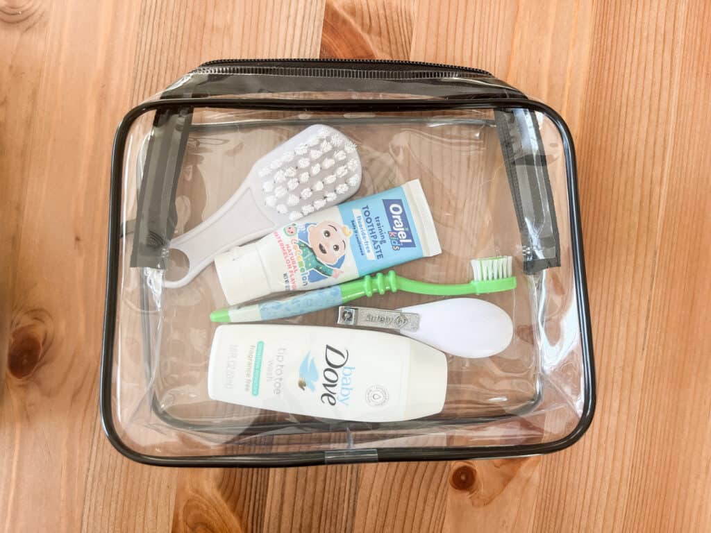 The smaller Packism clear toiletry bag holding toddler toiletries for a trip. There is plenty of room to spare!