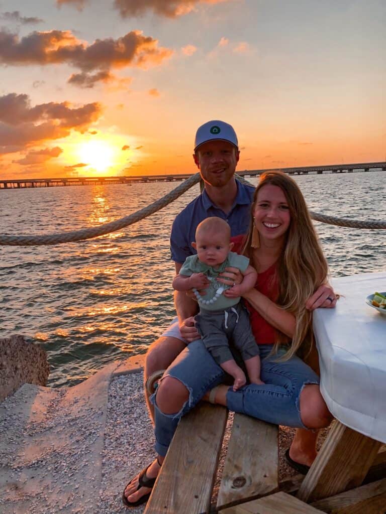 A young family watching the sunset from a table at Salt Shack.