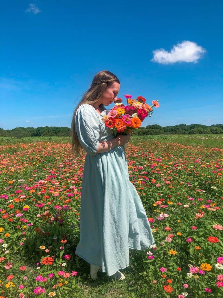 A woman smelling freshly picked flowers