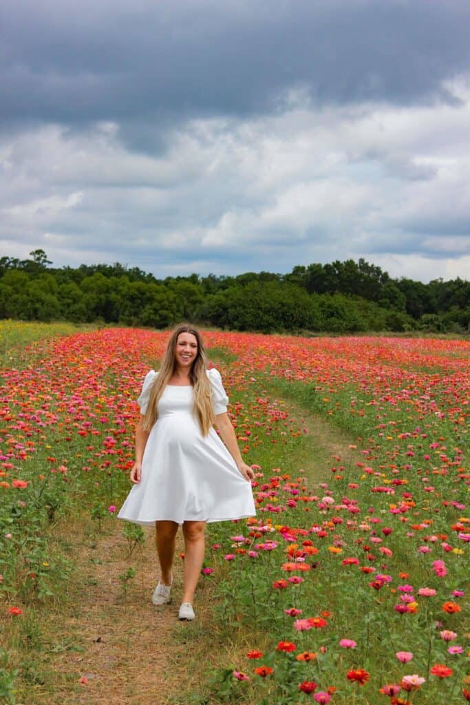learn how to pose with flowers by playing with your dress as you walk.