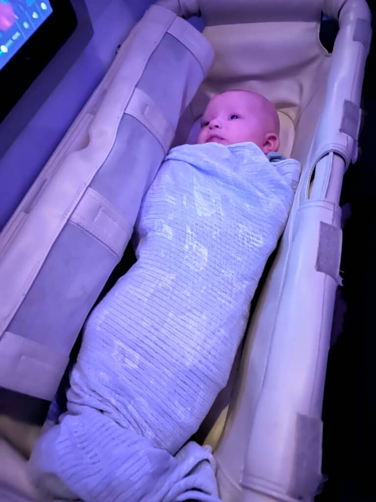 a baby in a travel cot