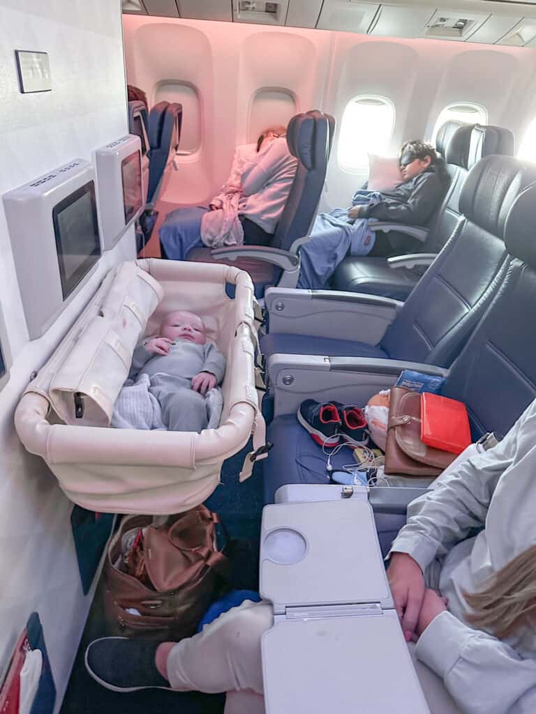 family traveling by plane with a baby in an airplane bassinet.